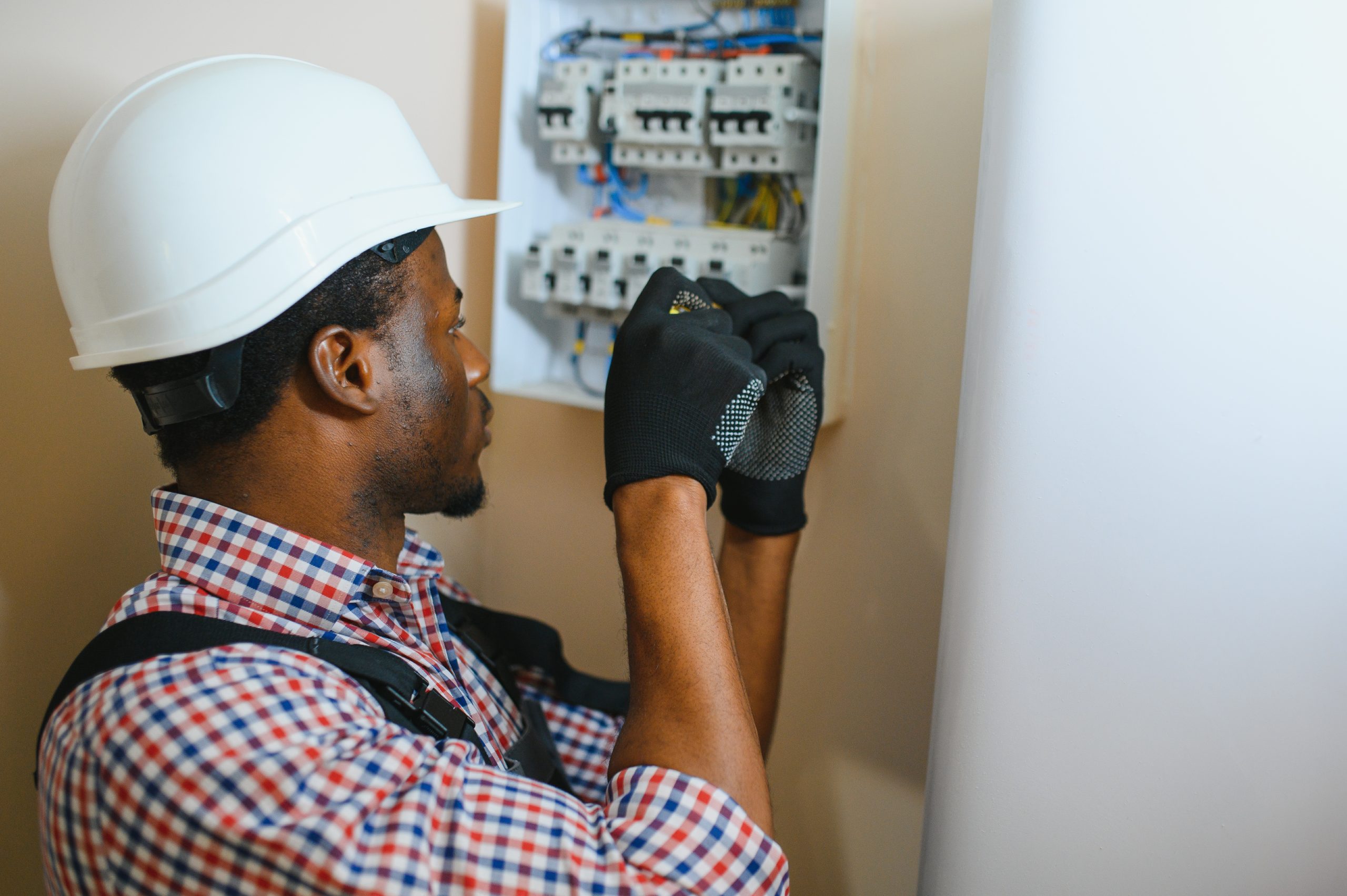 african american electrician repairing electricity switchboard photo